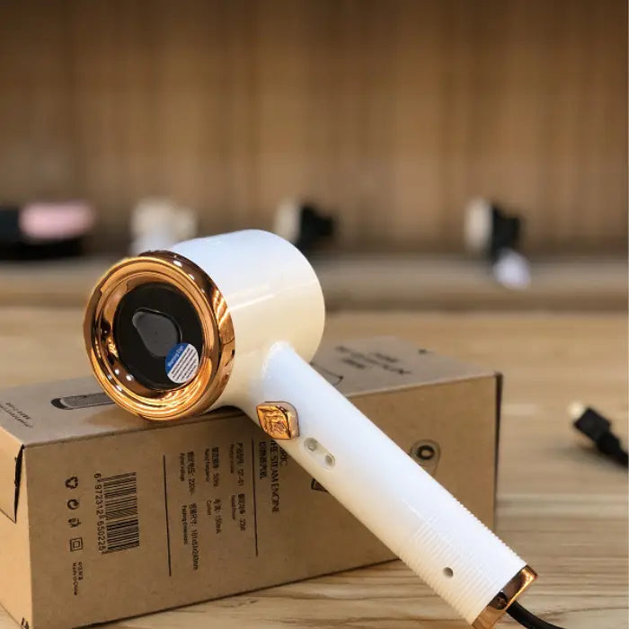  Travel steamer in white and gold color resting on box with power cord, ideal for portable use.