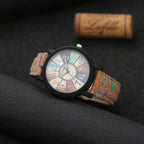 Trendy analog wristwatch with cork band and multicolor dial, photographed on a dark background for contrast.