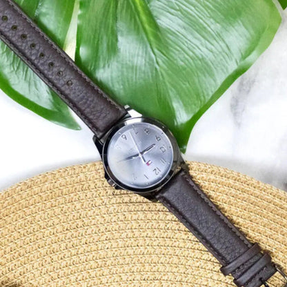 Tommy Hilfiger watch on straw hat with monstera leaf backdrop for summer fashion accessories