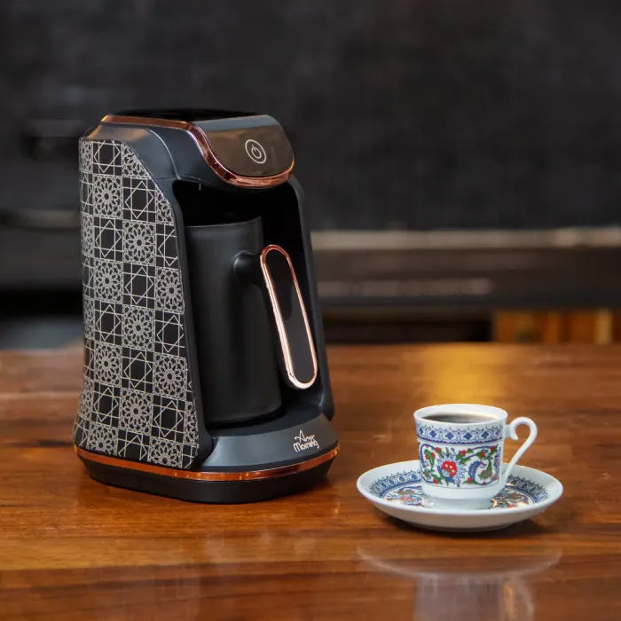 Electric Turkish coffee maker alongside traditional porcelain Turkish coffee cup and saucer