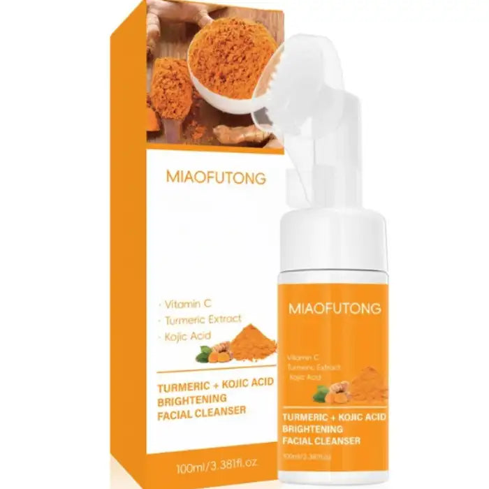 Turmeric skin cleanser bottle with brush and packaging featuring turmeric and kojic acid ingredients.