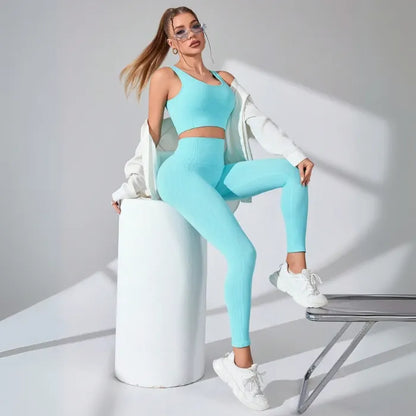 Seamless turquoise workout set with crop top and high-waisted leggings, styled with white chunky sneakers against studio backdrop