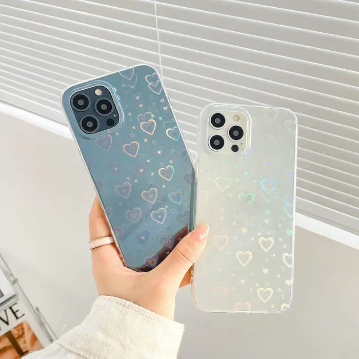 Two holographic heart pattern phone cases held together, stylish and protective smartphone accessories.