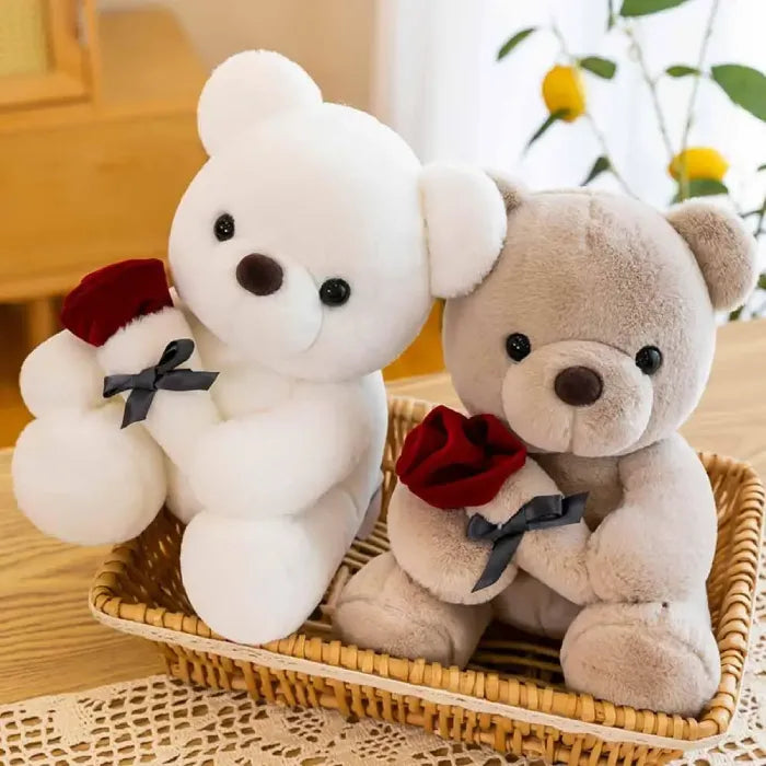 Two teddy bears, one white and one gray, sitting with red roses in basket.