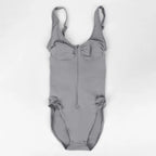 V neck shapewear bodysuit in grey shown flat on a white background, highlighting zipper front and soft sculpting fabric for supportive shaping wear