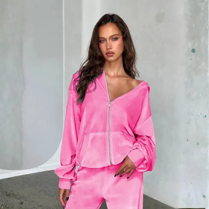 Velour tracksuit in pink close up featuring a plush zip hoodie with relaxed sleeves for cozy lounge ready comfort