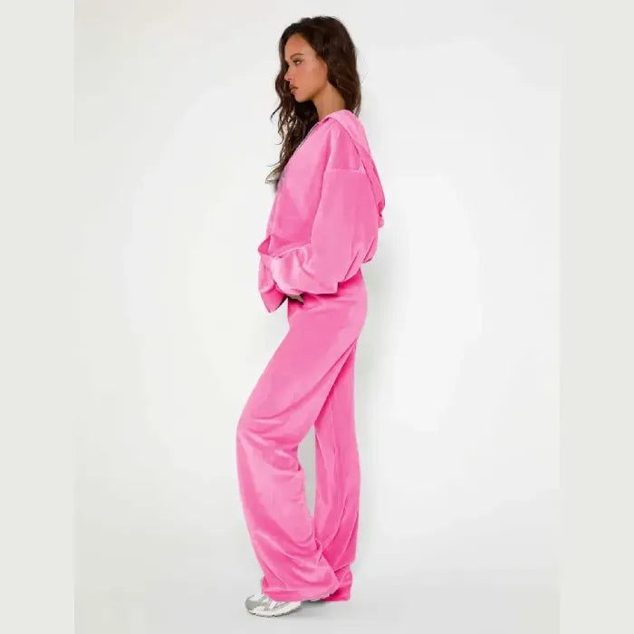Velour tracksuit in pink side view featuring plush hoodie and flowing pants for flattering fit and off duty comfort