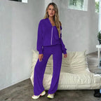 Velour tracksuit in purple styled in a lifestyle setting with zip hoodie and flowing pants for elevated lounge wear