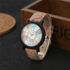 Vintage-style analog wristwatch with a cork band and colorful dial, placed near a wooden box for aesthetics.
