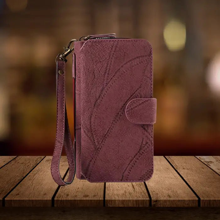 Wallet iPhone case crafted from premium burgundy leather with distinctive stitching pattern and durable metal hardware attachments