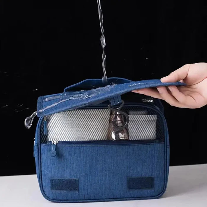 Blue toiletry bag with water being poured on it, demonstrating waterproof feature