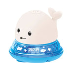 White whale bath toy with blue light-up UFO base and fun star pattern.