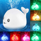 Whale bath toy spraying water with changing LED light colors in various shades.