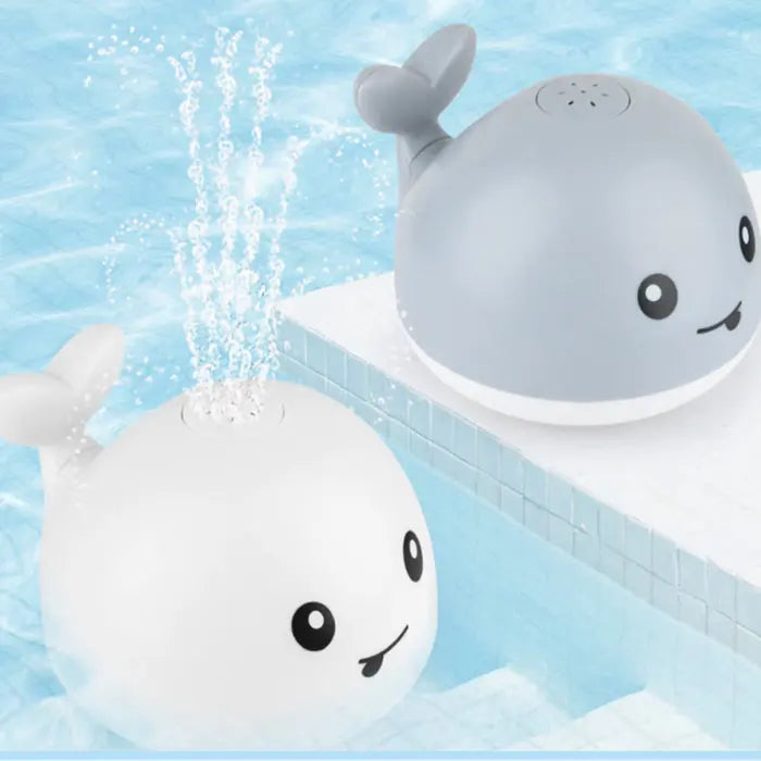Gray and white whale bath toys floating and spraying water in a clean swimming pool.