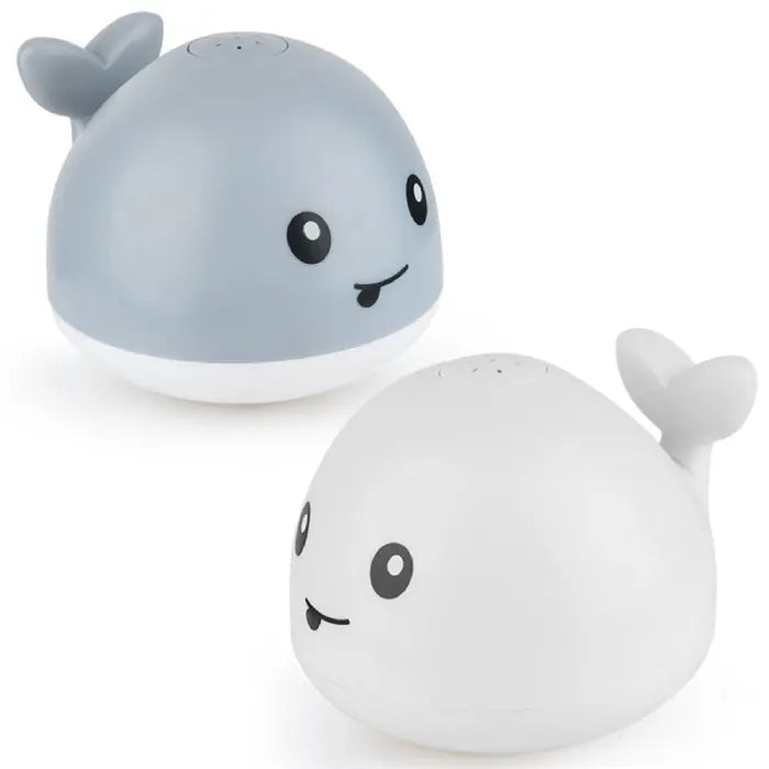 Whale bath toy with green and purple LED lights glowing during nighttime bath.