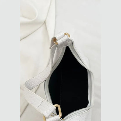 Open white croc-embossed bag showing black interior lining and gold-tone hardware details