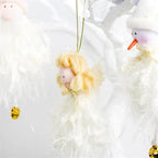 white christmas ornaments angel closeup plush with soft wings and gold bells, hanging on white tree beside santa figure