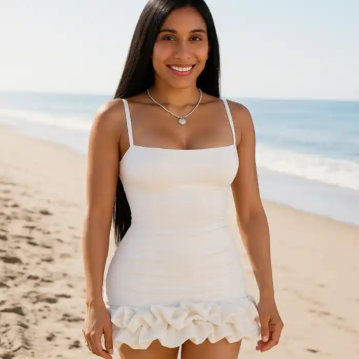 cocktail dress with white fabric and structured ruffle bottom photographed at oceanside location showing versatility for destination events