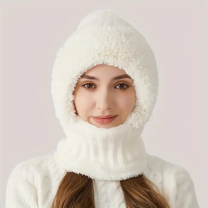 Person wearing a white faux fur hooded hat with knit trim framing their face