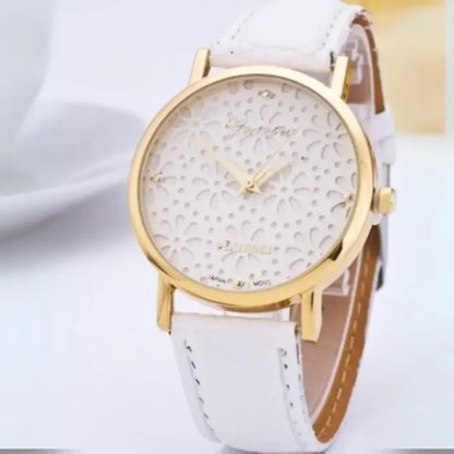 White women's watch with a gold floral-patterned dial and white leather strap.