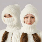 Woman wearing a white fluffy winter hat and balaclava mask combination with a hooded scarf design.