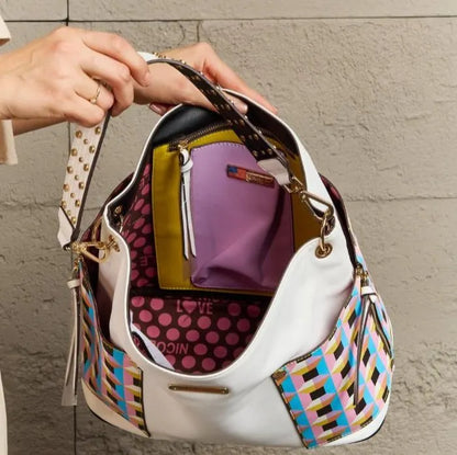 Open white handbag showing purple and yellow interior compartments with polka dot lining and multiple storage sections