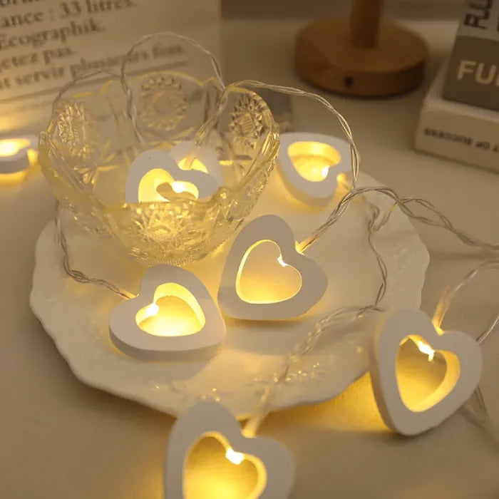 White heart lights arranged inside a glass bowl on a decorative plate.