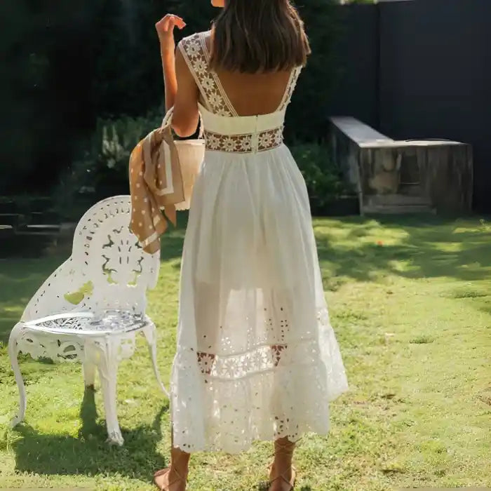 White lace midi dress with back cutout design shown from behind in garden.