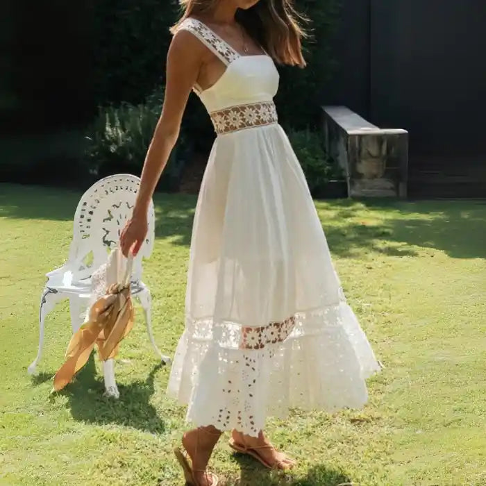 White lace midi dress with floral cutout panels flowing in sunlit garden.