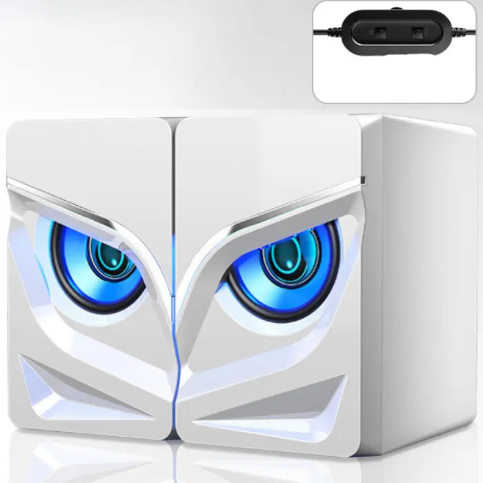 White computer speakers with owl-like blue glowing eyes, angular design, and USB controller on blue background