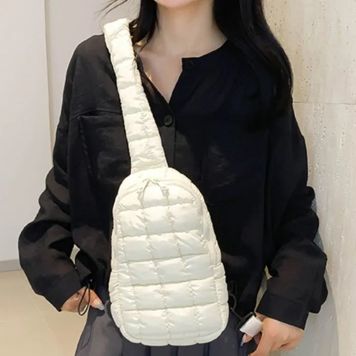 White puffer sling bag worn with black shirt, creating a striking monochrome outfit combination