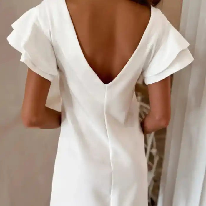 White ruffle sleeve shift dress back view highlights deep v-back and delicate flutter sleeves.