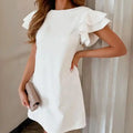 White ruffle sleeve shift dress side view showing flutter sleeves and relaxed shift shape.