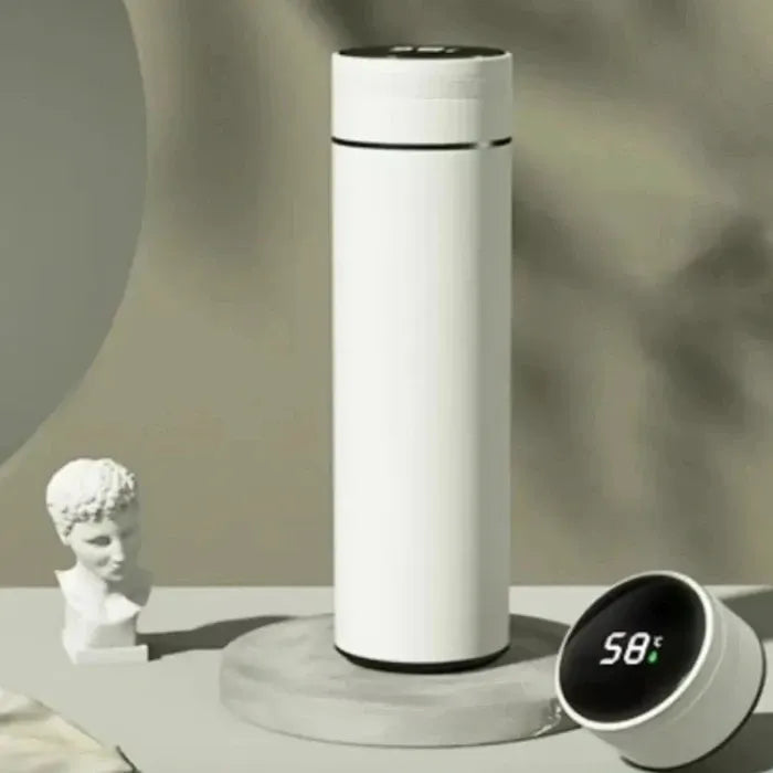 White smart bottle with temperature display on pedestal, classical bust sculpture nearby, cloudy background