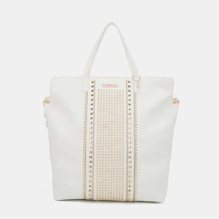 Designer white tote bag featuring decorative gold studs pattern and central panel with luxury hardware embellishments