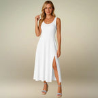 Model showcasing a crisp white sleeveless midi dress with a scoop neck and elegant side slit. Purchase this perfect casual summer dress online for parties or vacation