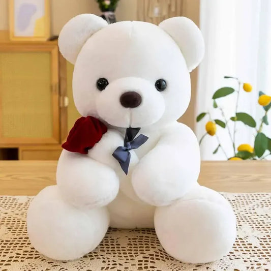 White plush teddy bear with a red rose and navy bow, perfect romantic gift idea.