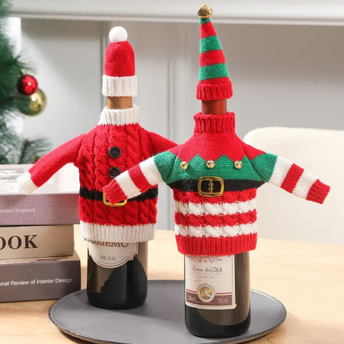 Wine bottles wearing festive Christmas sweater covers with matching hats displayed on gray serving tray with books