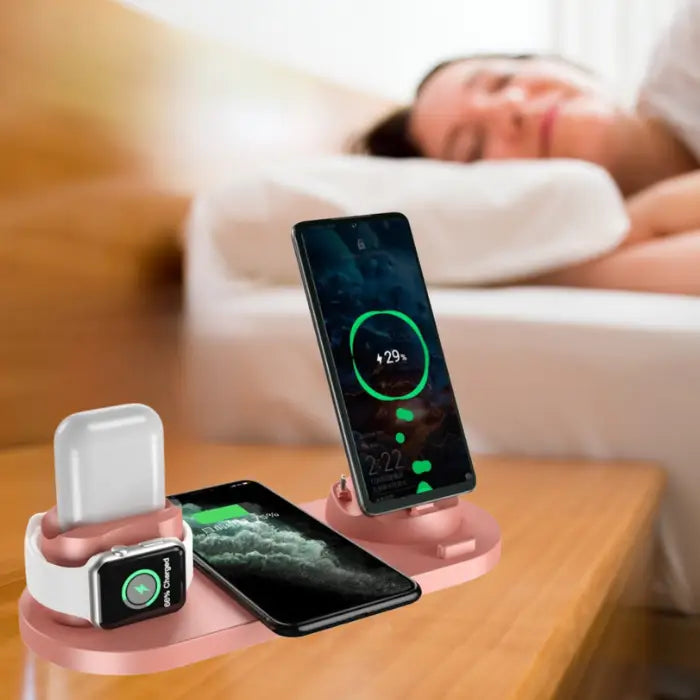 Wireless fast charging station in rose gold powering three Apple devices at once on night stand
