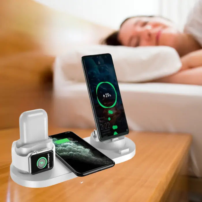 Wireless fast charging station in white with three devices docked and charging simultaneously on night stand