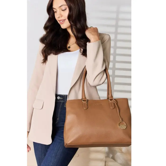  Fashionable woman posing with elegant brown handbag in modern setting.