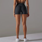 Womans yoga shorts in dark grey shown from back, highlighting ruched seam and supportive waistband.