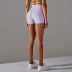 Womans yoga shorts in lavender purple shown from back, with scrunch detail and form-fitting cut.