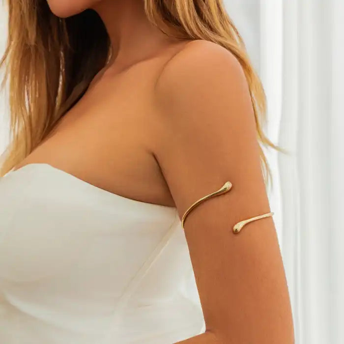 women wearing gold melted metal arm band styled on upper arm