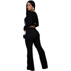 women two piece set black ribbed fabric shown from back with high waist wide leg pants and sleek long sleeve crop top.