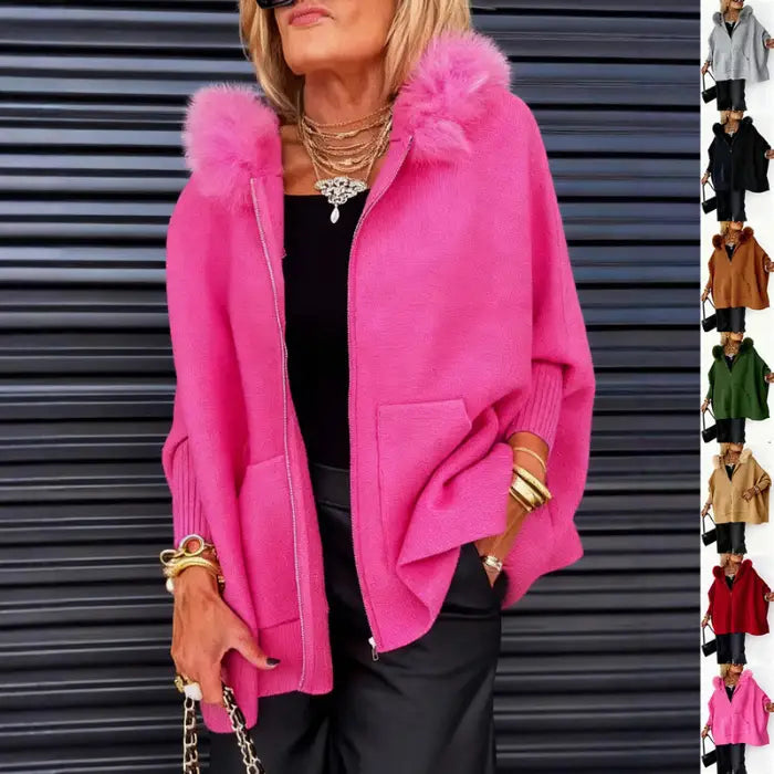 Women’s cape coat in pink with fur hood styled in urban setting, oversized pockets and draped fit creating bold chic winter fashion appeal
