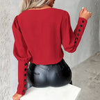 womens contrast v neck long sleeve blouse black trim in red shown from the back with button sleeve accents for a bold chic fashion style