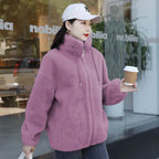 women’s faux fur jacket in muted pink worn casually while holding a coffee cup