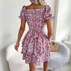  Women's flower print mini dress in pink back view featuring tied waist and puffed short sleeves.