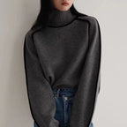 Women's Half Turtleneck Sweater in dark grey with black piping, paired with blue jeans for casual wear.